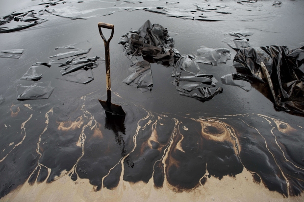 TOPSHOTS A shovel sits in oil-covered sa
